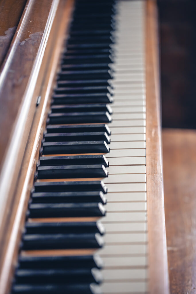 Piano keys on wooden brown musical instrument.